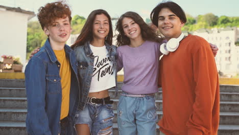 a group of teenage friends of two girls and two boys look directly into the camera and smiles 1