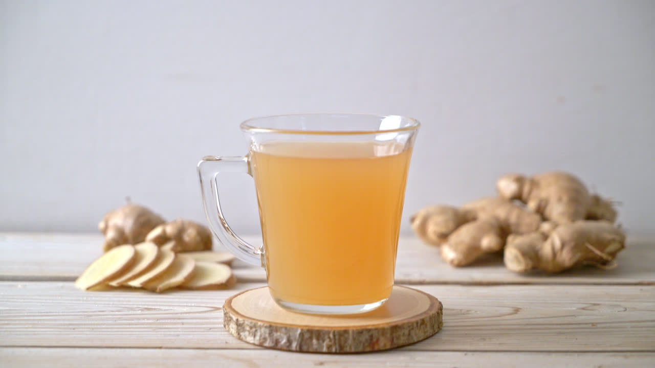 vaso de jugo de jengibre fresco y caliente con raíces de jengibre - estilo de bebida saludable