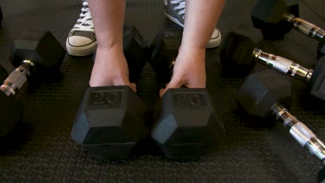 woman working out grabbing the dumbbells