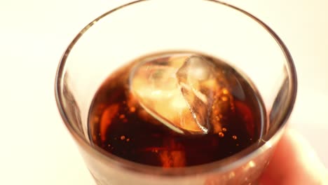 cola drink with ice cubes inside crystal clear glass isolated on white