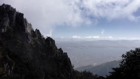 dramatic mount cangshan mountain peak in yunnan china, cloudy high aerial view