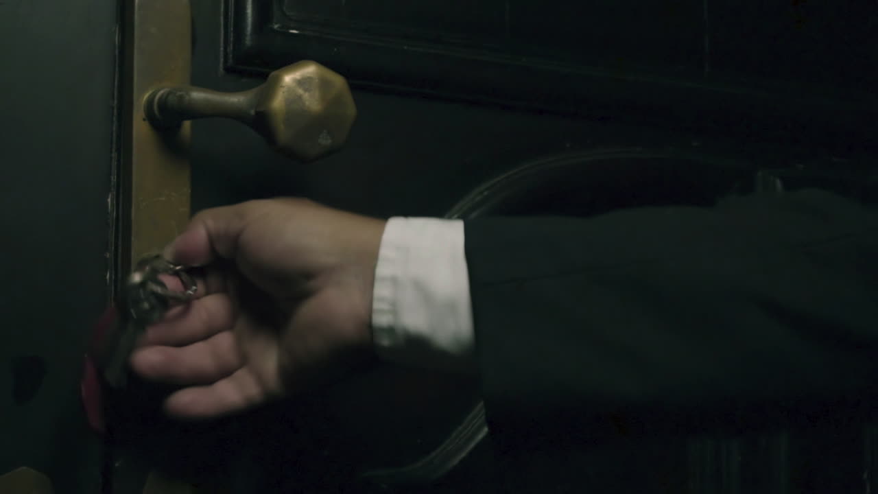 hombre de negocios abriendo una puerta con su llave llegando a una casa misteriosa en la noche