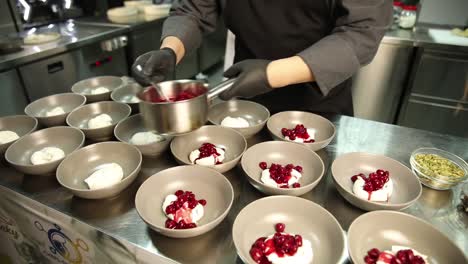 chef preparing a dessert with panna cotta and cherries