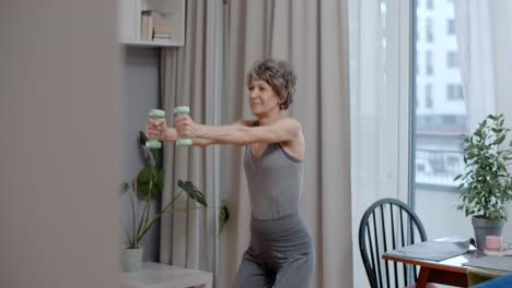 senior woman exercising at home with dumbbells