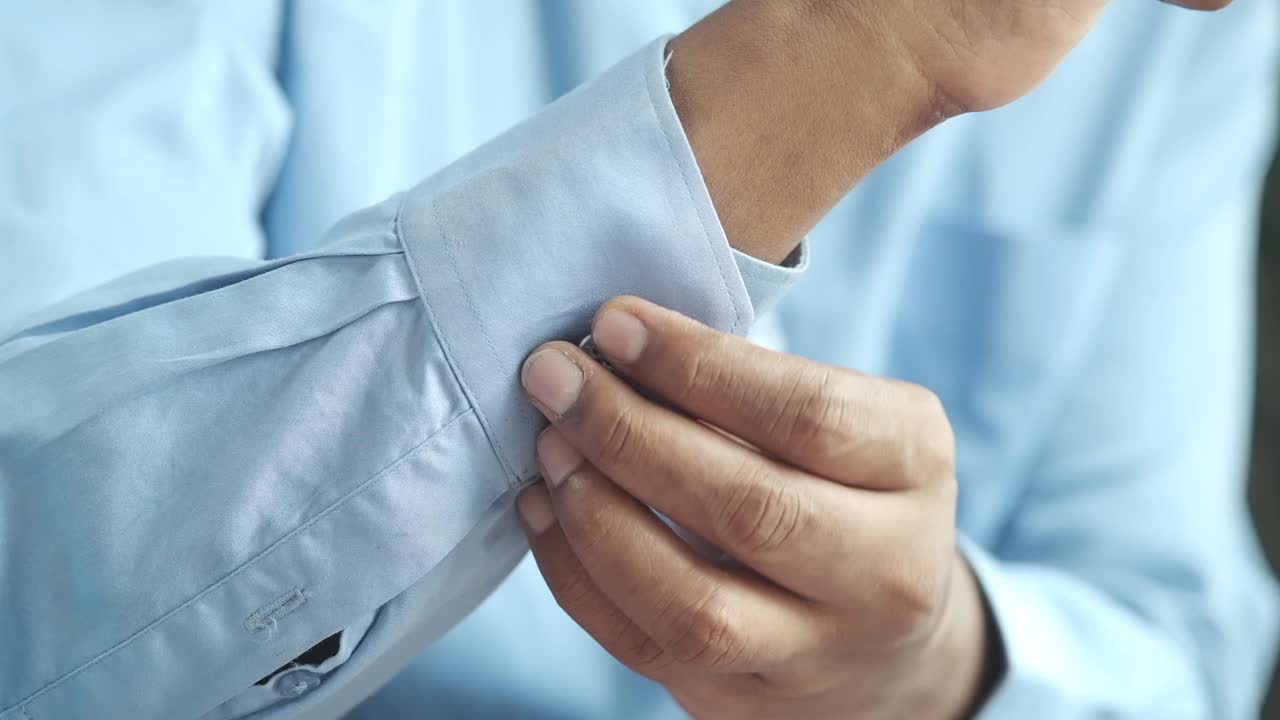 Man adjusting shirt cuff