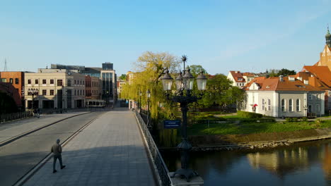 poste de luz vintage junto al puente sobre el río brda en bydgoszcz, polonia con peatones caminando durante el día