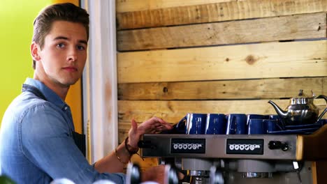 camarero usando la máquina de espresso en el mostrador