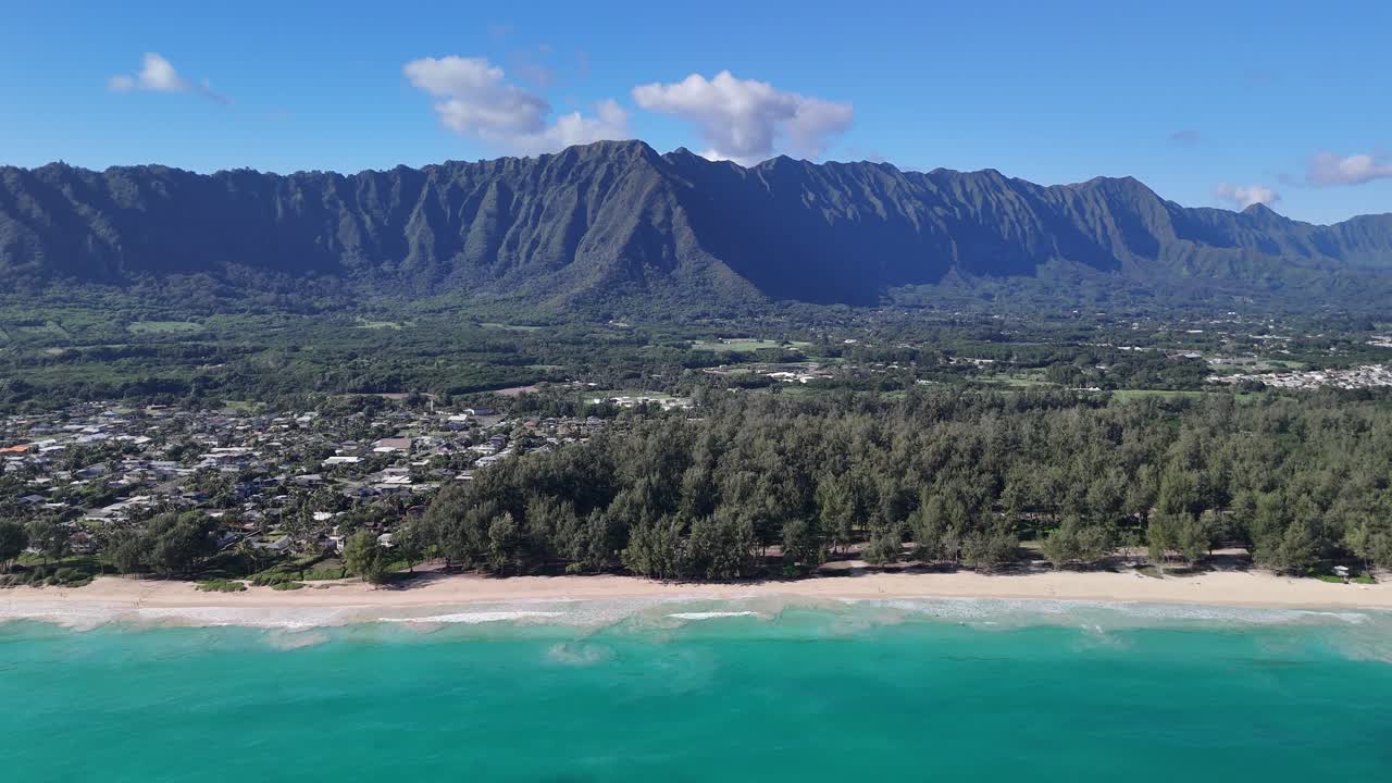 Vista 4K rialzata della spiaggia di Waimanalo a Oahu, nelle Hawaii, che mostra uno splendido oceano e una spiaggia di sabbia bianca con le montagne Koolau sullo sfondo e la città di Waimanalo