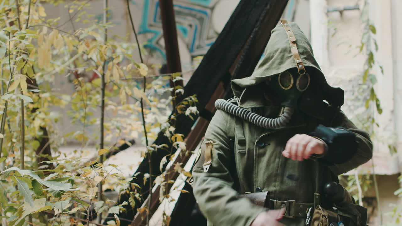 보호복을 입은 과학자가 손에 들고 있는 장치를 보고 방독면을 쓰고 보호하고 있었다