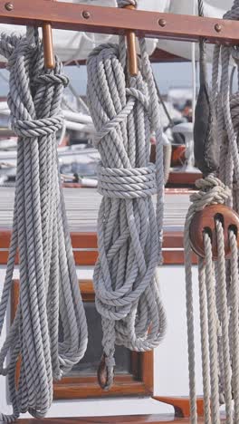 coiled boat deck ropes neatly hang vertically on rigging of sailing yacht