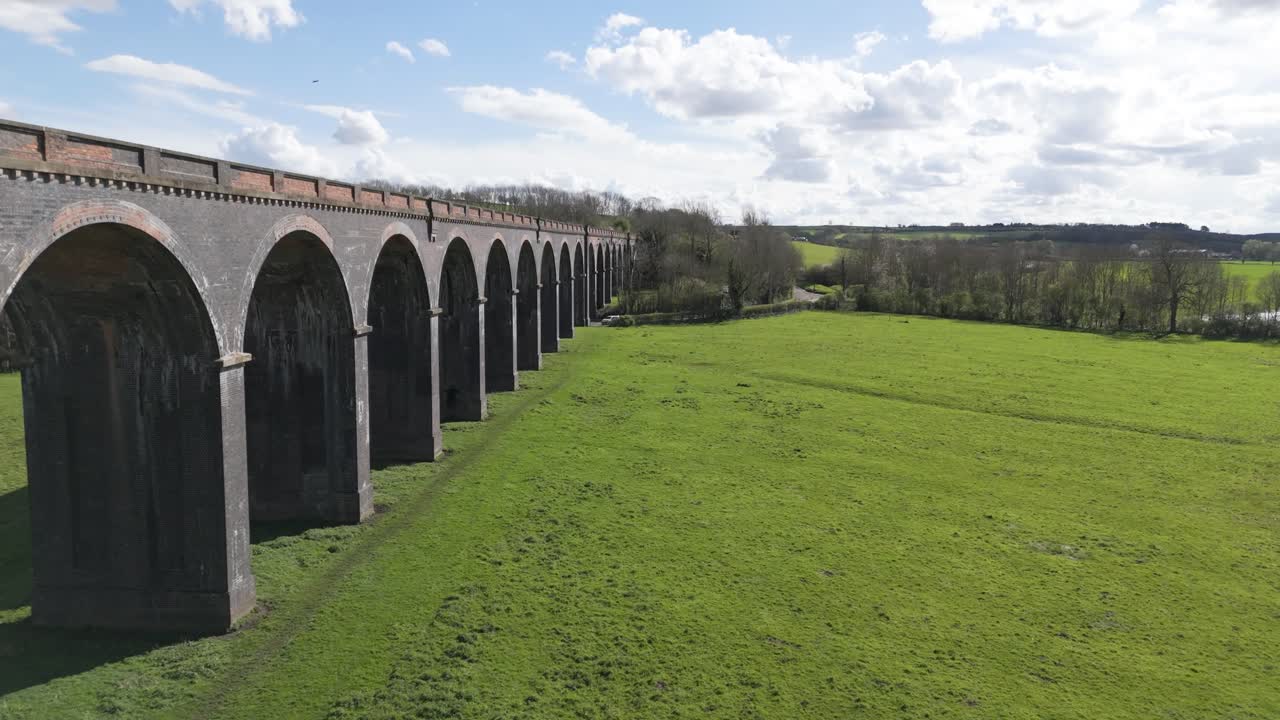 Volo di drone a bassa quota lungo gli archi del Viadotto di Welland nel Northamptonshire, noto anche come Viadotto di Harringworth e Seaton, in una giornata di sole