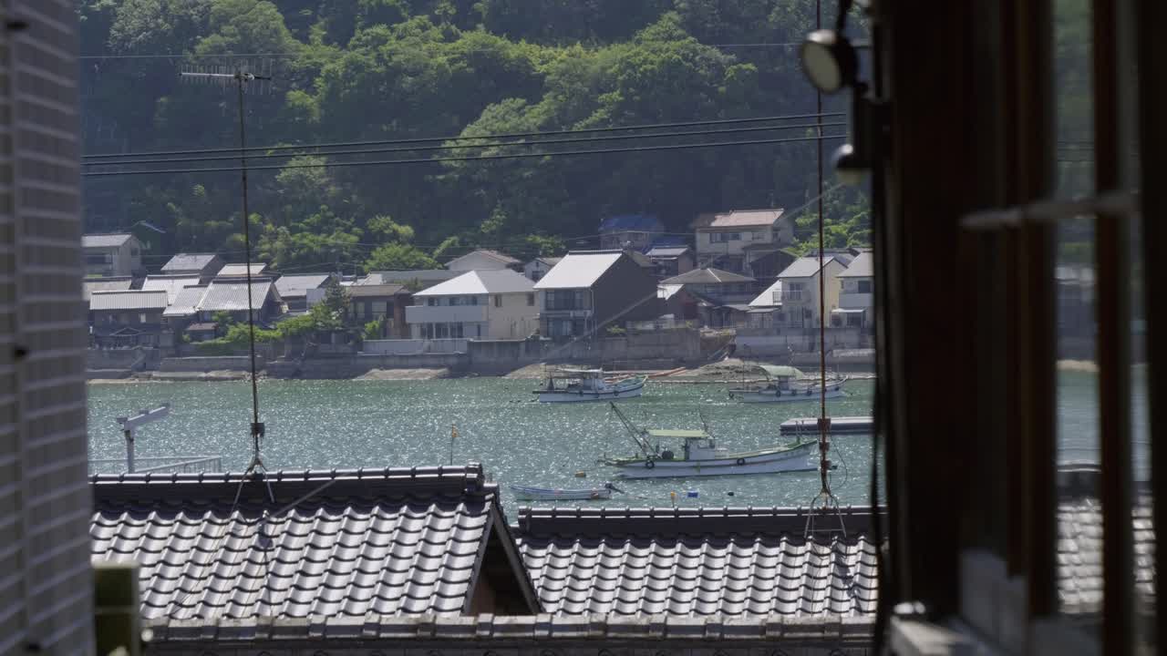 Stunning slow motion slider shot in between buildings looking out at ocean Village in Japan