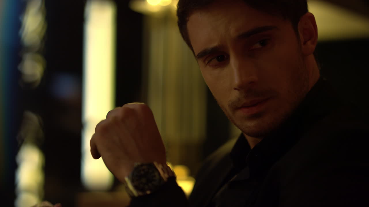 Rich businessman looking at camera in dark room