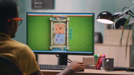 Vertical of Young Black Man Under House Arrest Playing Videogame on Couch
