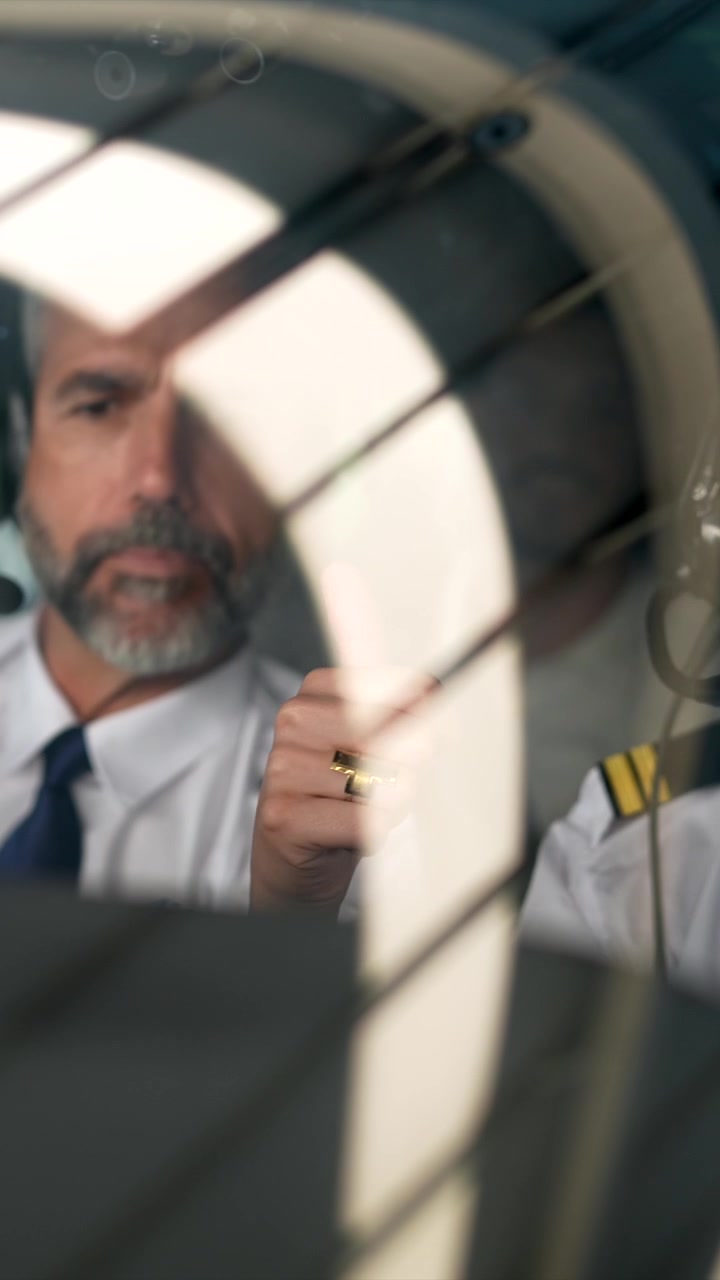 Pilota esperto che istruisce il copilota nella cabina di pilotaggio dell'aereo