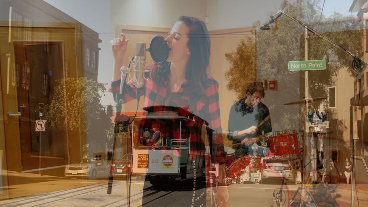 Batterista che inizia il ritmo, cantante che canta al microfono, gesticolando, con una sovrapposizione di un tram che si muove attraverso l'inquadratura per la musica