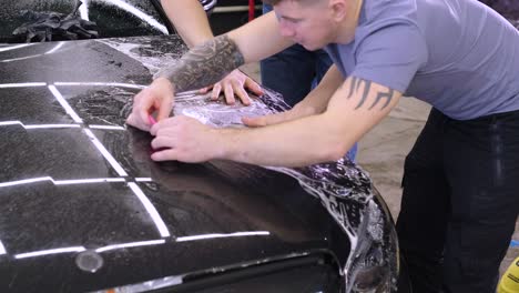 man covering car with vinyl polyurethane tape. films for the car. sticker protective film on the car