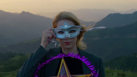 slow motion shot of a woman holding a small mask up to her face in the halloween spirit