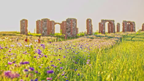 Timelapse-shot-of-tourists-walking-around-Medieval-castle-ruins-in-Latvia,-Europe