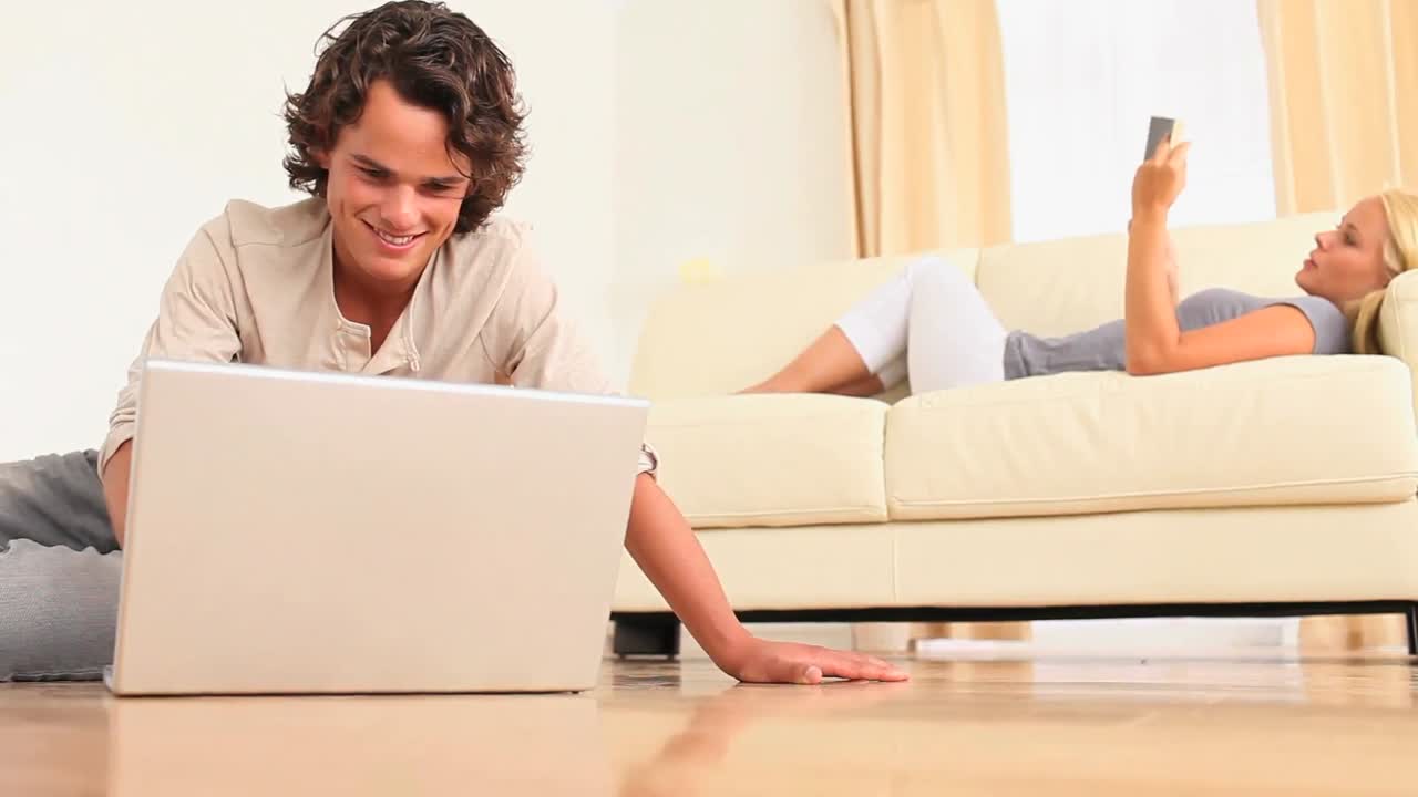 mujer leyendo mientras su hombre está buscando en la web
