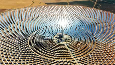 beautiful large circular power plant of solar panels in spain. there is the reflection of the sun in the the panels which produce renewable energy, solar energy - close-up view with a drone - environment concept