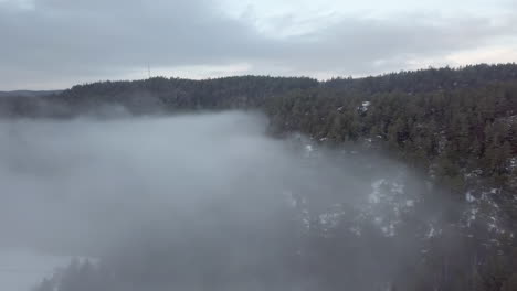 Aéreo,-Disparo-De-Drone,-Panorámica-Sobre-Una-Espesa-Nube-De-Niebla,-Rodeado-De-Bosques-Y-Colinas-Heladas,-En-Una-Mañana-Brumosa-De-Otoño,-En-Birkeland,-Aust-agder,-Sur-De-Noruega