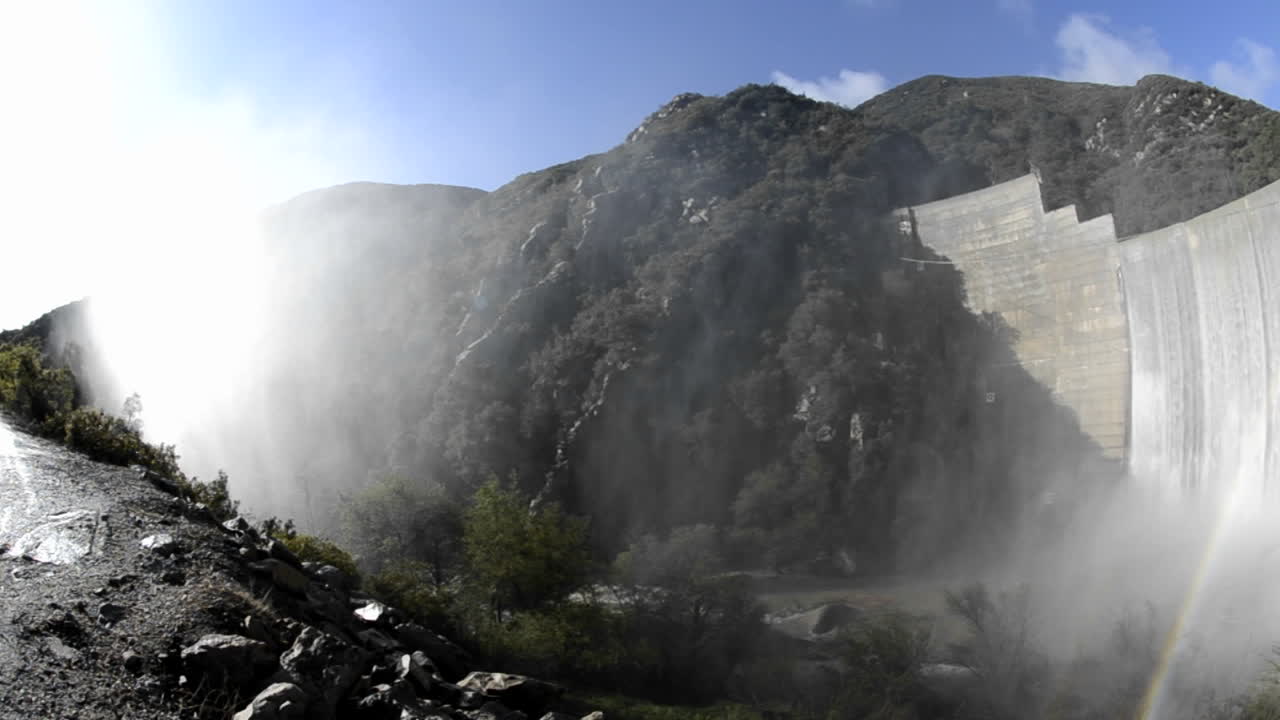 구식 마틸리야 댐 위로 쏟아지는 마틸리야 크릭 아래 무지개의 광각 패닝 샷