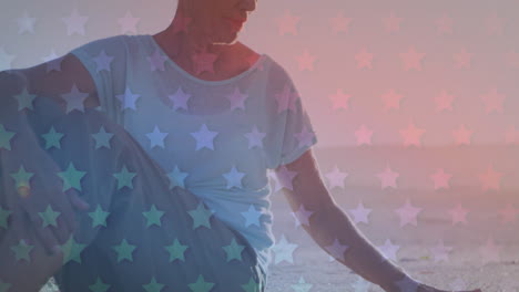 animación del patrón de la bandera estadounidense sobre una mujer mayor sentada en la playa