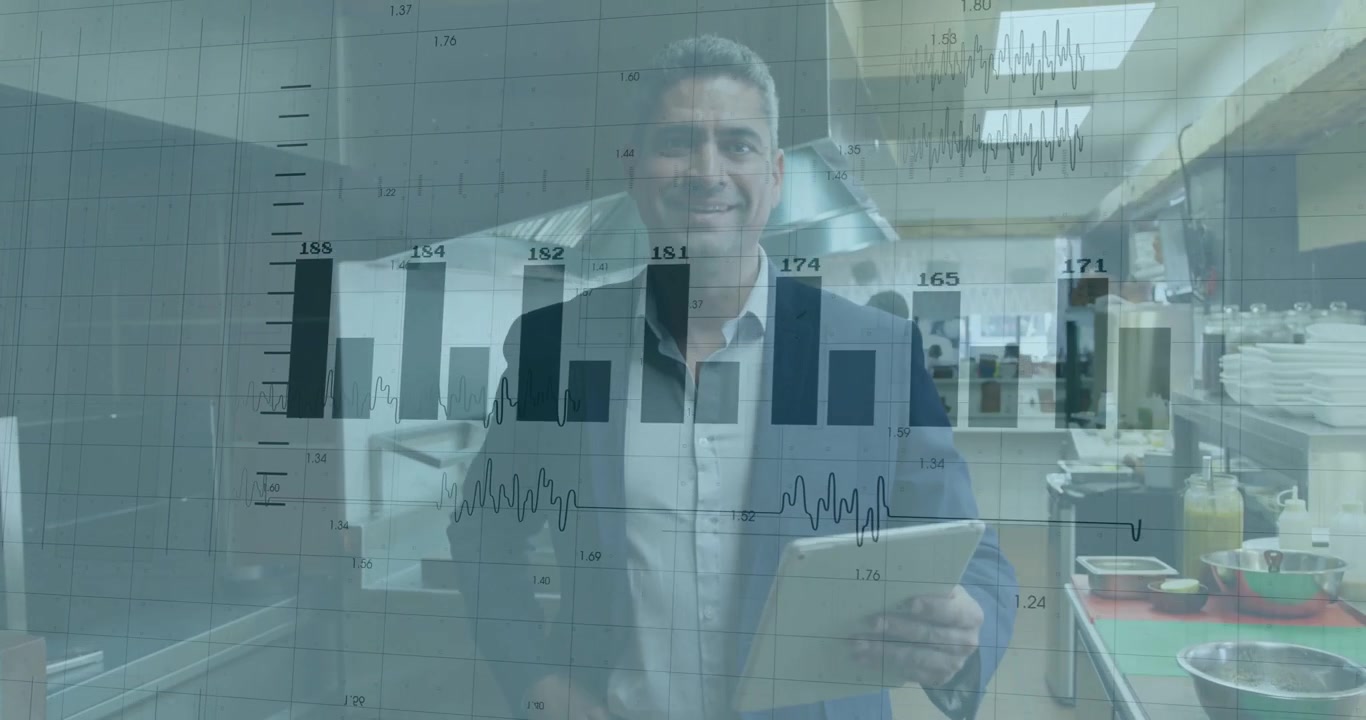 Uomo maturo in blazer scuro che tocca lo schermo, consulta un tablet nella cucina di un ristorante, mostrando grafici sovrapposti.