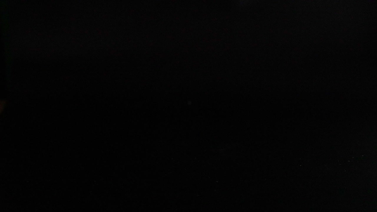 Various colored tennis balls bouncing in darkness