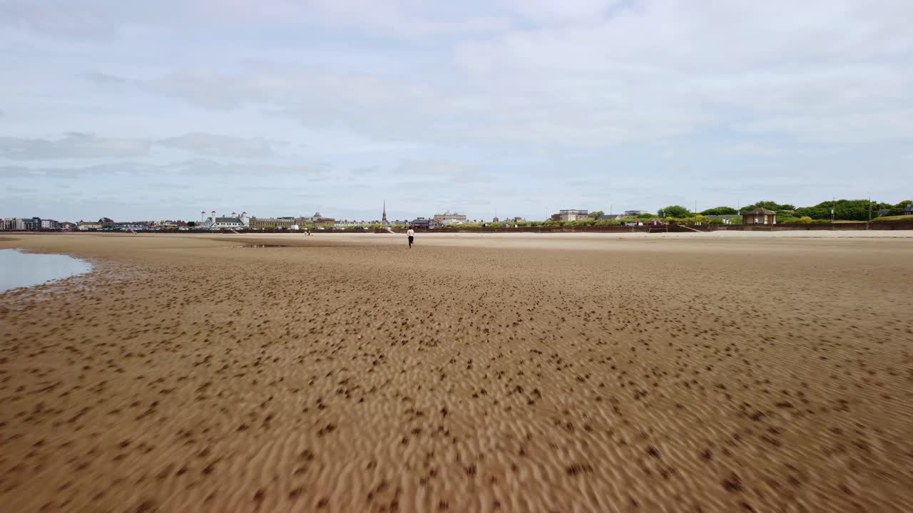 모래 와 물 이 있는 해변 에서 멀리 달리는 성인 남성