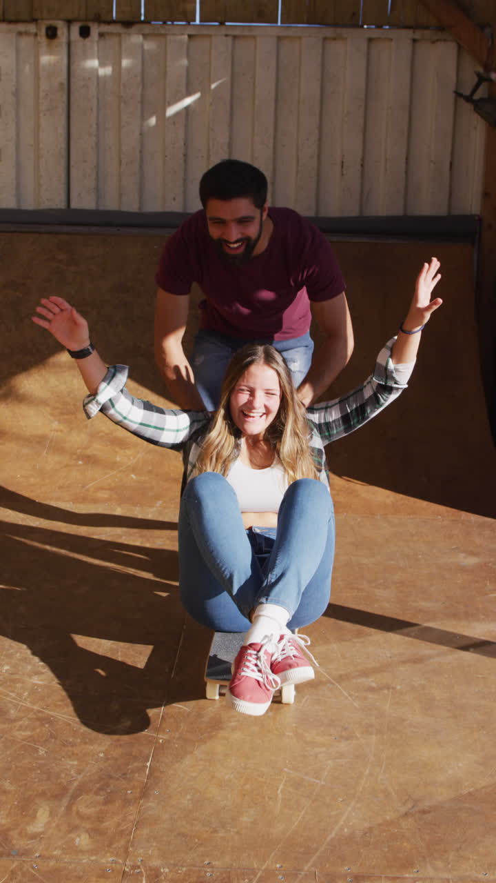video vertical de diversas patinadoras femeninas y masculinas divirtiéndose en el parque de patinaje