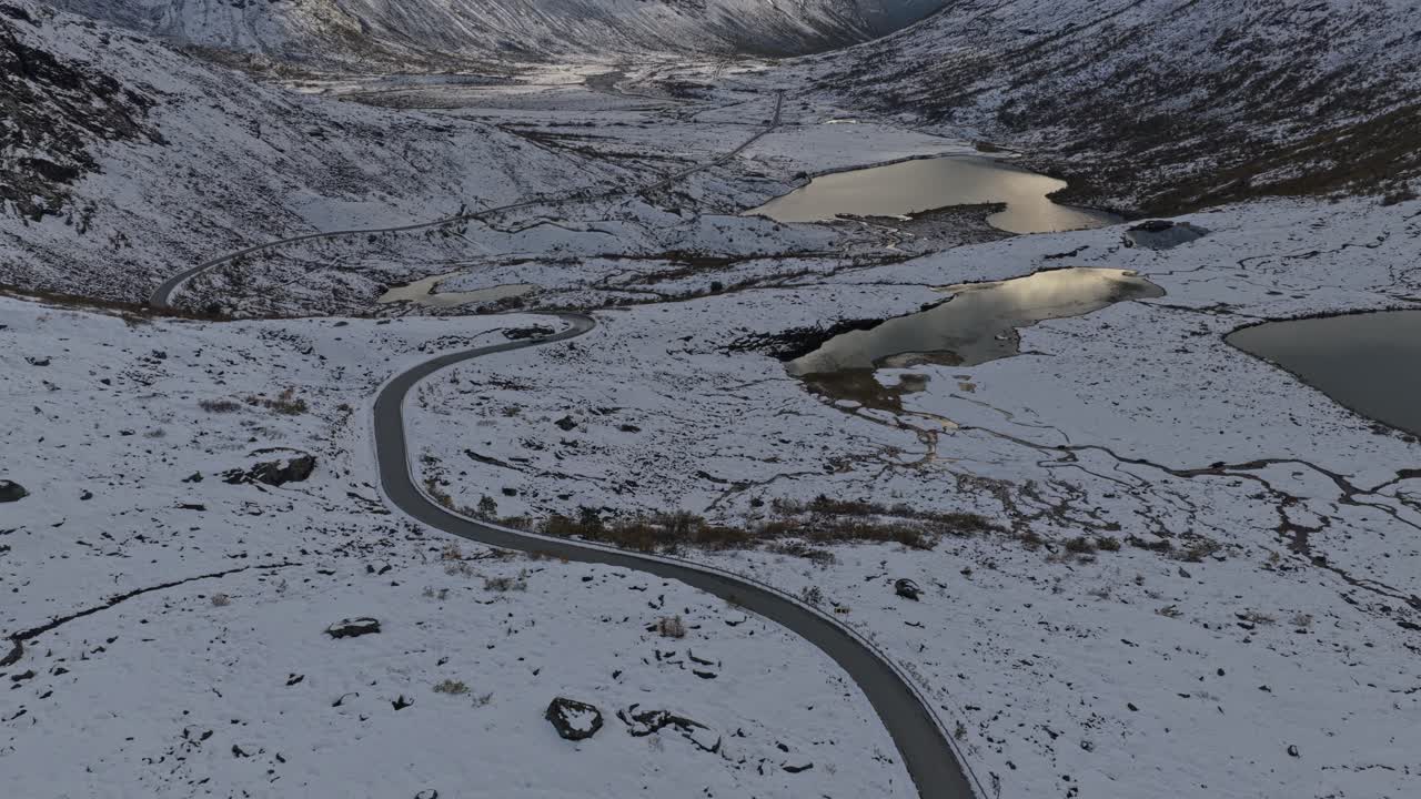 Aerial shot of RV traveling remote alpine road in winter, Norway