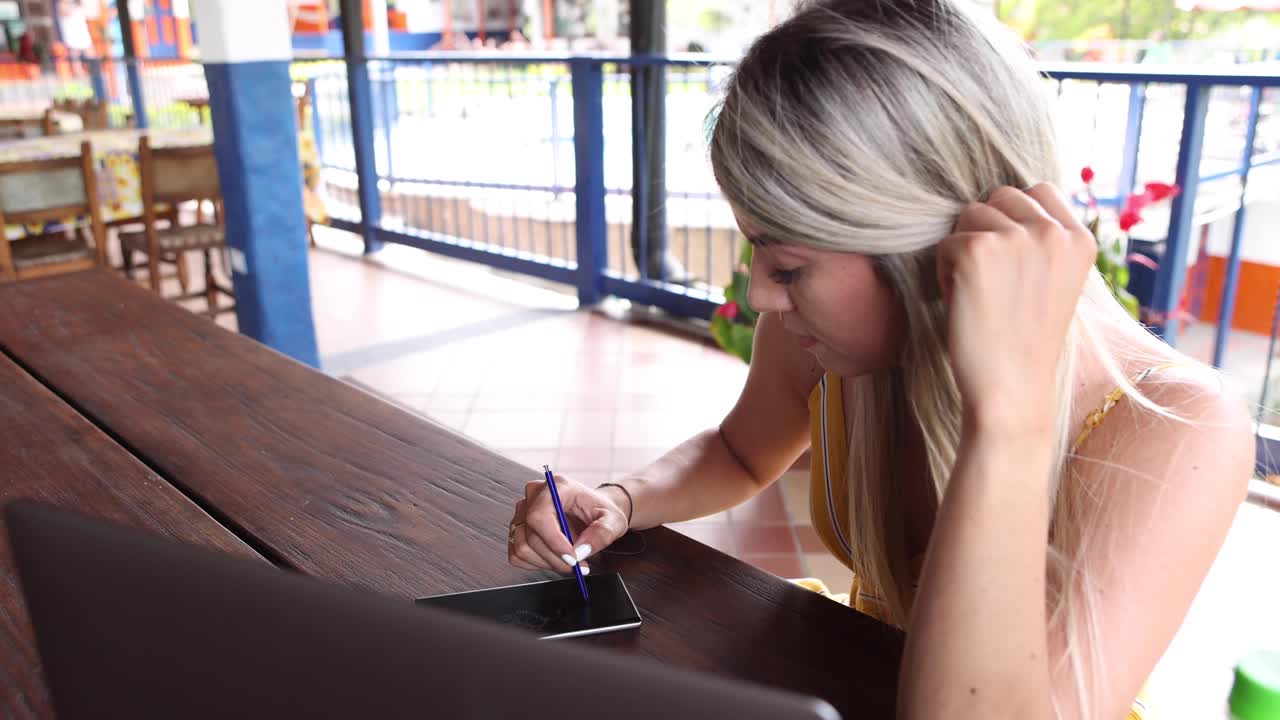 mujer usando teléfono inteligente y computadora portátil en la terraza