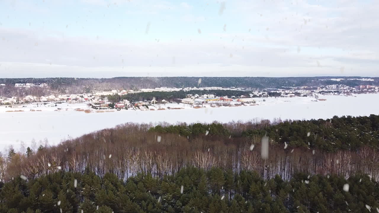 폭설이 내리는 겨울철 지평선에 얼어붙은 호수와 마을, 공중 드론 전망