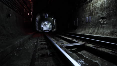 mysterious tunnel with tracks leading into darkness at an underground location