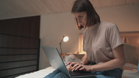 Mujer-Joven-Sentada-En-Mala-Postura-Y-Usando-Una-Laptop-En-La-Cama