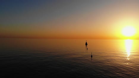 Scenic-golden-sunset-over-the-calm-tropical-ocean-with-buoys