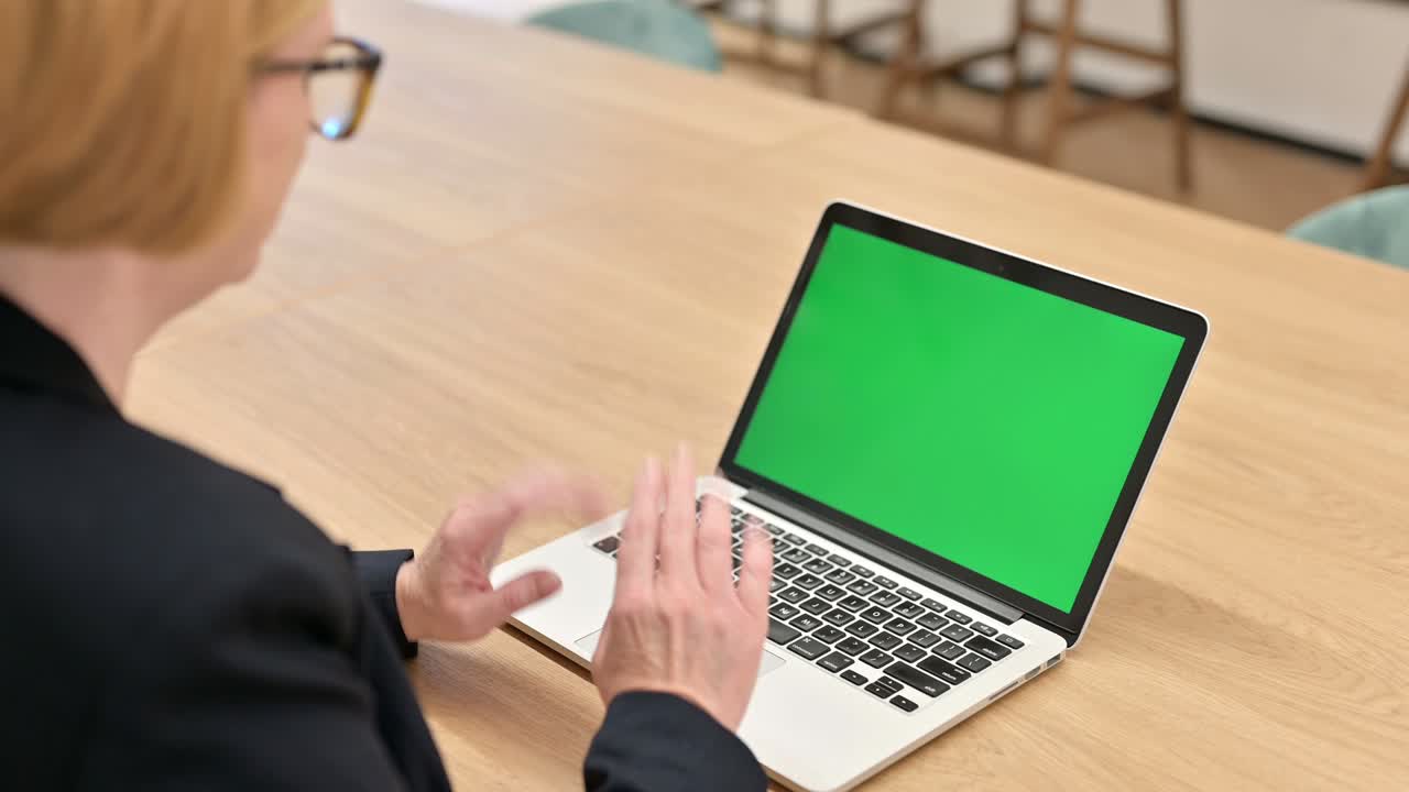 Senior Businesswoman using Laptop with Chroma Screen