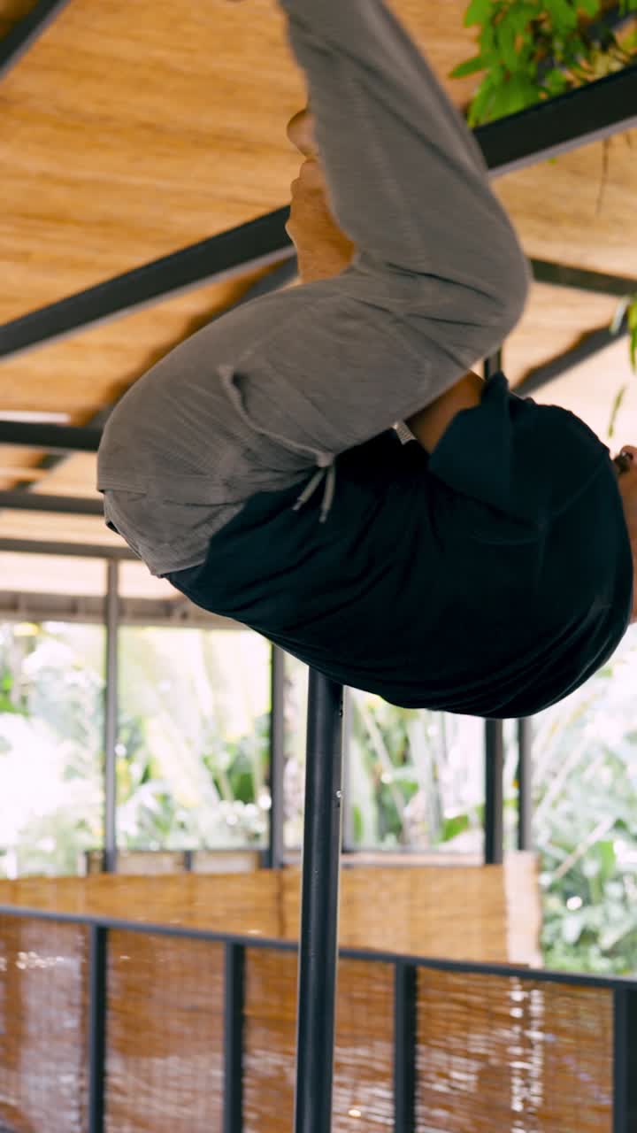 Uomo che esegue un allenamento di calisthenics al palo in una palestra all'aperto