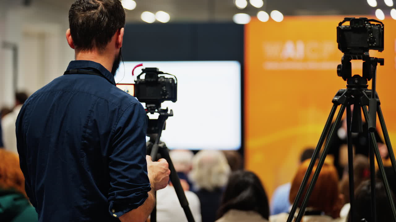 Man filming with a professional camera at a conference