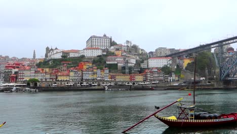 Vista-Panorámica-Del-Casco-Antiguo-De-Oporto-Con-Ponte-Luis-I-Y-Barco-Rabelo-Amarrado-En-Un-Día-Lluvioso