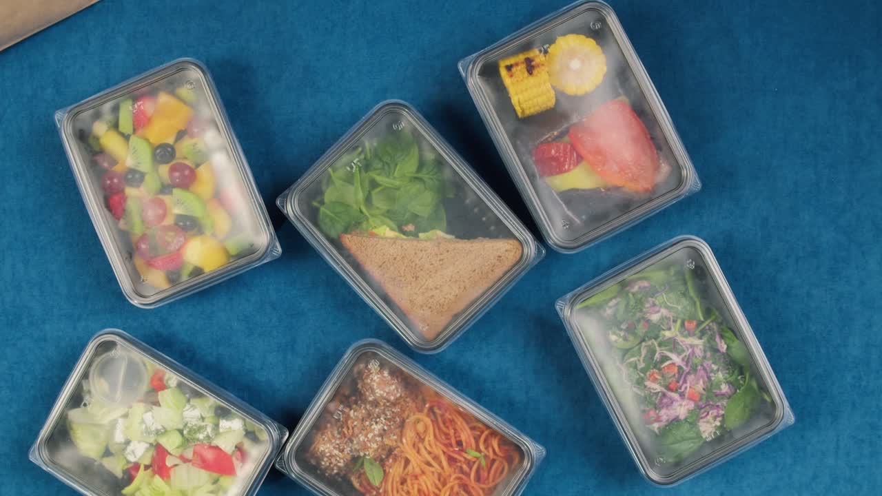 様々な健康的な料理の配達ミールを開梱する手