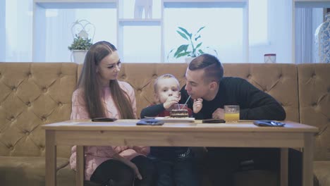 lucky-smiling-parents-play-with-small-son-sitting-on-sofa