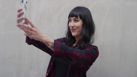 Retrato-De-Una-Joven-Tatuada-Usando-Un-Teléfono-Inteligente-Posando-Tomando-Una-Foto-Selfie-Sonriendo-Feliz-Disfrutando-De-La-Tecnología-De-Telefonía-Móvil-Compartiendo-Conectividad