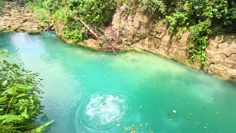 a man umps from a 10meter platform while canyoneering at kawasan falls in cebu, philippines