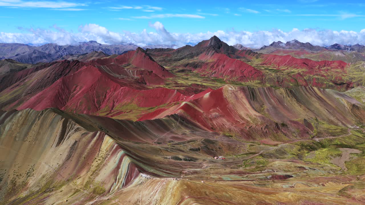 Rainbow Mountain Vinicunca Peru aerial drone morning blue sky Montaña de Siete Colores Palccoyo Pallay Punchu cloud Peruvian Andes Red Valley seven colored striped hills seven colored backwards circle