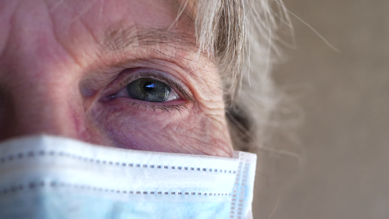 Primo piano del volto di un'anziana signora e occhiali da vista con una mascherina per pazienti per prevenire la diffusione di malattie o il rischio di ammalarsi