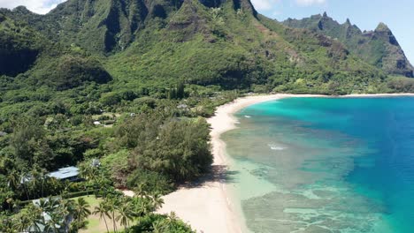 Toma-Aérea-Volando-Sobre-La-Playa-De-Haena-E-Inclinándose-Hacia-Las-Icónicas-Montañas-Hawaianas-De-Kaua&#39;i