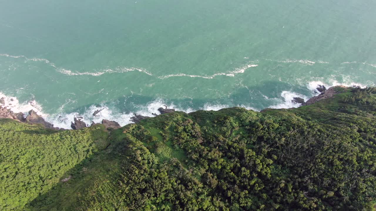 vista aérea de una isla rocosa irregular, rodeada de naturaleza verde y exuberante y agua de la bahía de hong kong